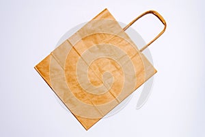 Brown kraft paper bag for shopping on white background top view copy space mockup. Top view package