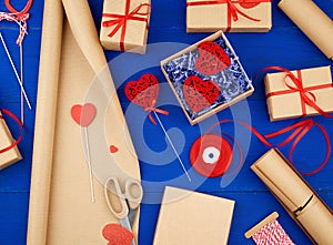 Brown kraft paper, packed gift boxes and tied with a red ribbon, red heart, set of items for making gifts
