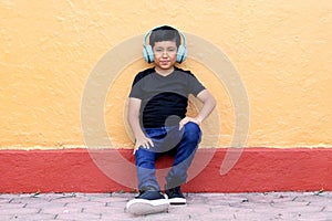 Brown Latino 9 year old boy with anti noise headphones for children with asperger syndrome, autism spectrum disorder, ADHD