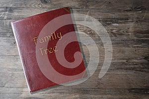 Brown leather board on wooden background, scrapbook family tree in Leather, concept family genealogy, memories, generational ties
