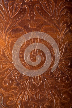Brown leather book or journal cover with a decorative floral ornament