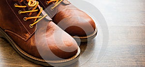 Leather boots shoes on the brown wooden table background.with copy space.