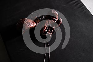 Brown leather boxing gloves on a training mat black background top view