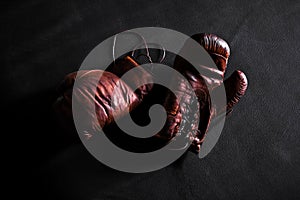 Brown leather boxing gloves on a training mat black background top view