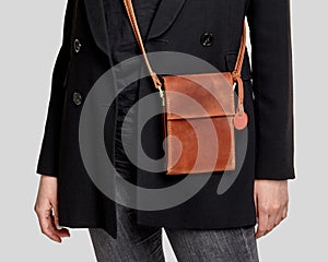 Brown leather crossbody messenger bag complementing stylish feminine look