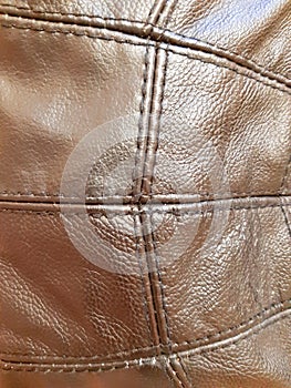 Brown leather fragment of clothing stitched. Background design, photography. Textile, fabric template, modern new