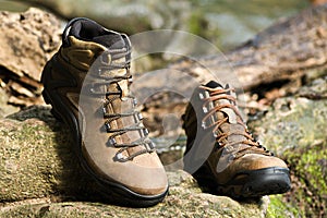 Brown leather hiking boot on wood.