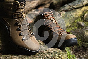 Brown leather hiking boot on wood.