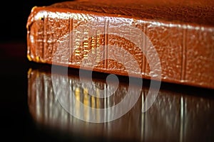 Brown Leather Holy Bible with Reflection in Table Top.