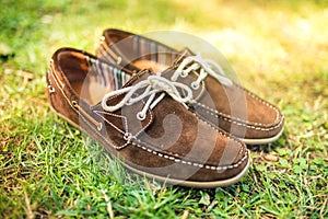 Brown leather mens shoes, elegant summer moccasins in grass. Men fashion, men accesories and footwear.