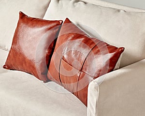Brown leather pillows complementing modern light-grey sofa