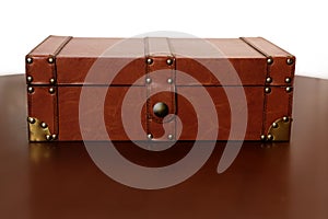 Brown leather suitcase over warm wood