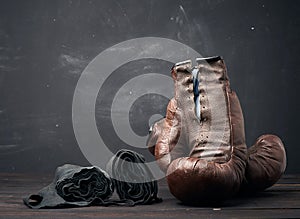 Brown leather vintage boxing gloves and black elastic bandage for hands