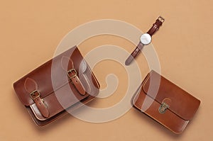 Brown leather women bag, stylish wristwatch on brown beige background top view flat lay copy space. Fashionable women`s