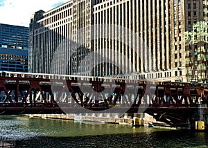 Brown line el train crosses elevated track over the Chicago River alongside the Merchandise Mart.
