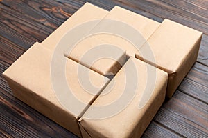 Brown mail package parcel blank for you design. Cardboard box on a dark wooden background