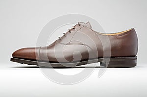 Brown man's shoe on a graduated background