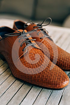 Brown man shoes with laces on wooden background