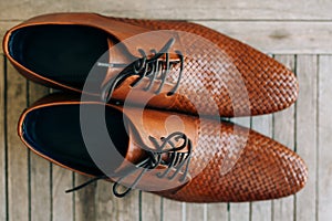 Brown man shoes with laces on wooden background