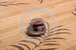 Brown massage stones composition on bamboo placemat