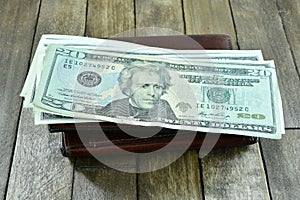 Brown mens wallet and dollars