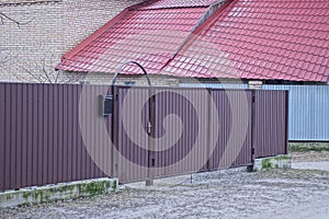 brown metal door and gate on an iron fence wall