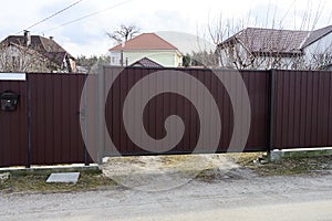 Brown metal gate and door on a fence wall