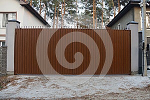 Brown metal gate and fence on a rural street