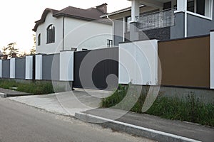 Brown metal gate and white concrete fence in the street