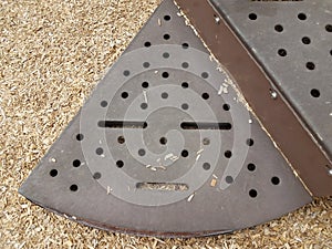 Brown metal step on play stucture that looks like a face