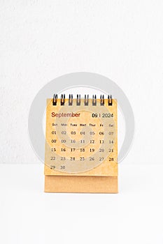 Brown mini desk calendar for September 2024 on white