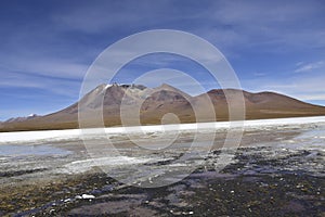 Brown mountains in the background. Off-road tour on the salt flat Salar de Uyuni in Bolivia