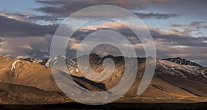 Brown mountains with Light and shadow and dramatic sunset clouds