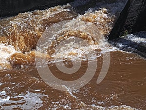 Brown muddy water of Erft river in a weir in Grevenbroich in Germany