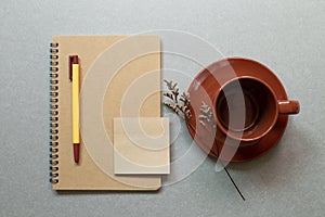 Brown notebook, pen, coffe cup on gray desk background. workspace. flat lay, top view, copy space