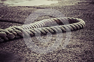 Brown old anchor rope at ship dock pier