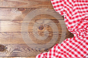 Brown old vintage wooden table with framed red checkered tablecloth.Thanksgiving day and Cristmas table concept. Top view.