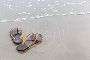 Brown and orange beach slippers on sandy ocean beach, summer vac