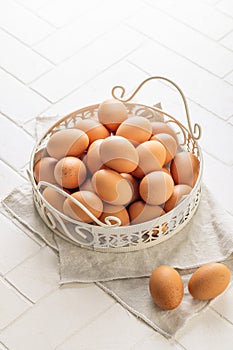 Brown organic eggs in a basket on kitchen table
