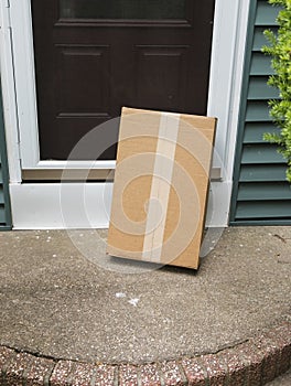 A brown package is left vulnerable at front door