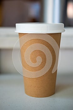 Brown paper cup with white lid of hot coffee