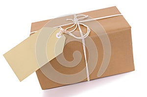 Brown paper package with white string, manila label or gift tag isolated on white background