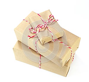 brown paper parcel tied with red and white string on white background
