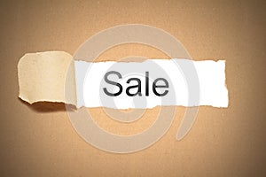 Brown paper torn to reveal sale