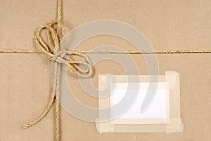 Brown parcel background with address label and string, copy space