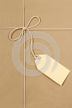 Brown parcel paper background, tied with cream cotton string, large label, vertical