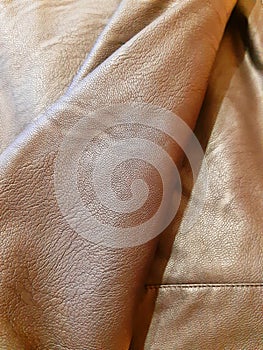 Brown piece of leather surface with bend, fold. Background design, photography. Textile, fabric template, modern new