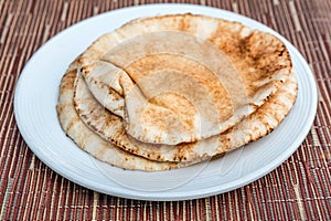 Brown pita bread on a white plate