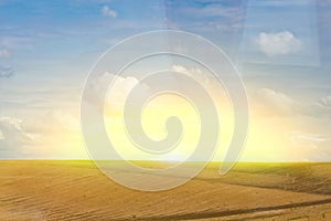 Brown plowed non-seeded field on a background of blue summer sky. sunny sky over an empty meadow. serenity, bliss. desktop