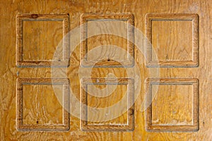 Brown plywood door texture with squares carved into it